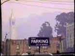 city parking lot sign with University in background